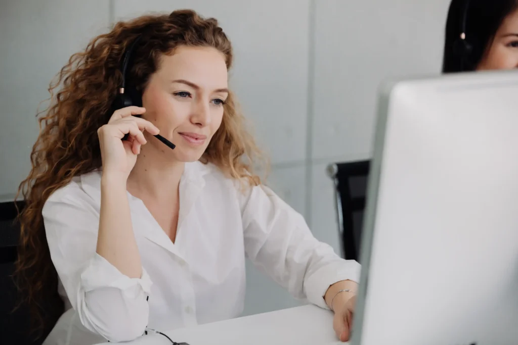 A call center worker on the phone looking at the computer.