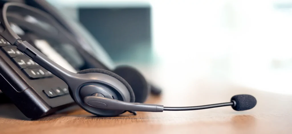Telephone with headset sitting on a desk.